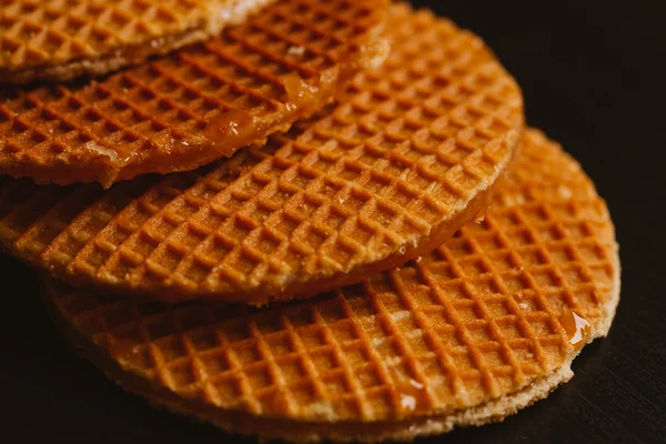 Waffeln mit Karamell auf schwarzem Hintergrund in Nahaufnahme — Stockfoto