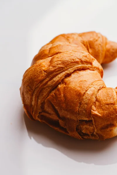 Croissant fresco da massa folhada em um fundo branco — Fotografia de Stock