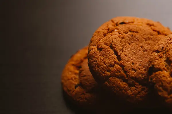 Frische Kekse mit Schokolade auf dunklem Hintergrund — Stockfoto