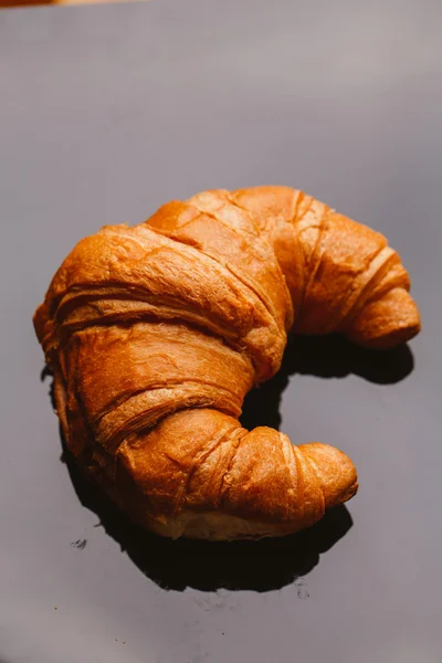 Fresh croissant from the puff pastry on a black background — Stock Photo, Image