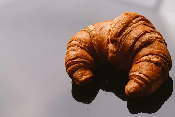 Verse croissants uit het bladerdeeg op een zwarte achtergrond — Stockfoto