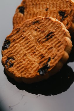 Kuru üzüm yakın çekim karanlık bir arka plan ile taze kurabiye