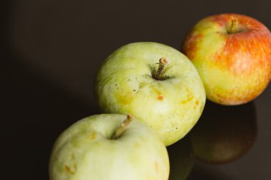 karanlık bir arka plan üzerinde birkaç taze olgun elma