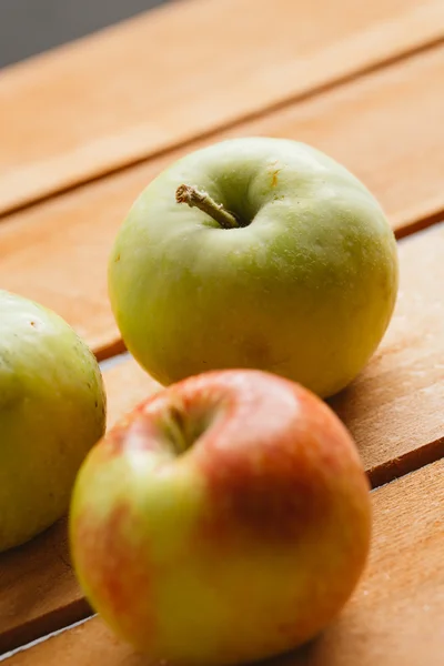 Несколько свежих спелых яблок на деревянном фоне — стоковое фото