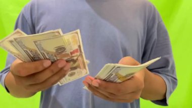 Yeşil arka planda dolar sayma manzarası. Yeşil arka planda dolar kullanarak ödeme yapmanın bir çizimi..