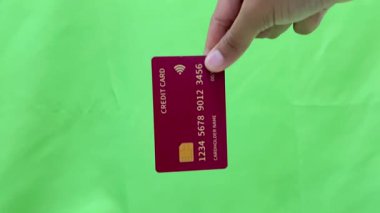 Yeşil arka planda el ele tutuşan kredi kartı görüntüsü