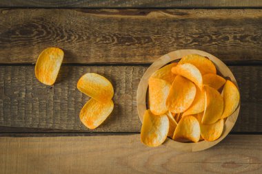 Masanın üzerinde bir ahşap kase cips
