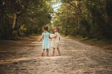 iki küçük kız bir orman yolu yürümek