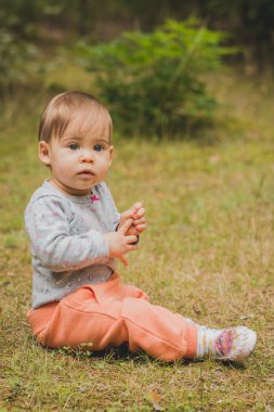 ormandaki çimlerde oturan bebek