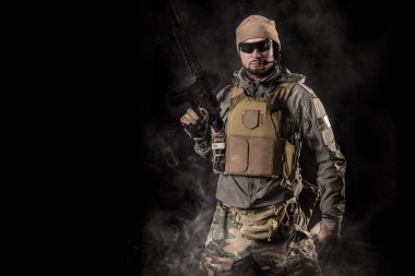 Siyah arka plan üzerinde saldırı tüfeği ile Özel kuvvetler operatörü