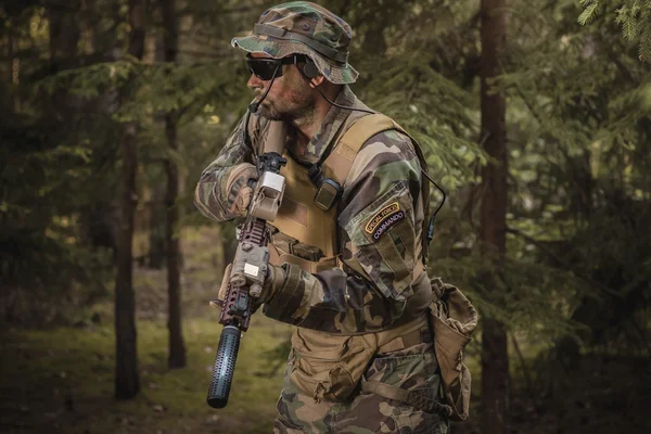 Soldier with a rifle in the woods — Stock Photo, Image