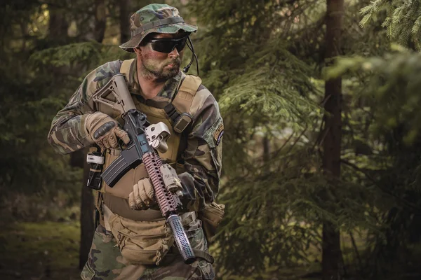 Soldado con un rifle en el bosque — Foto de Stock