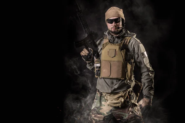 Operador de forças especiais com rifle de assalto em fundo preto — Fotografia de Stock