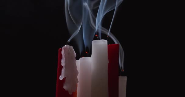 Дым от красных и белых свечей на черном фоне — стоковое видео