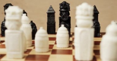 Tahta bir satranç tahtasındaki siyah ve beyaz satranç taşları