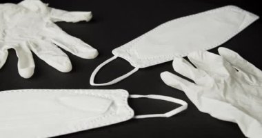 Siyah arka planda beyaz maske ve lastik eldivenler