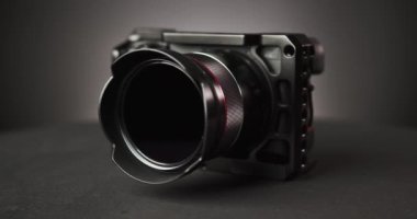 Siyah arkaplan üzerinde dönen fotoğraf makinesi