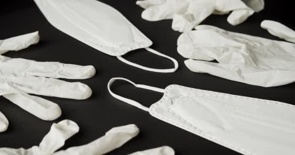 White mask and rubber gloves on a black background — Stock Video