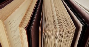 Siyah ve kahverengi kapaklı dönen güzel eski kitaplar.