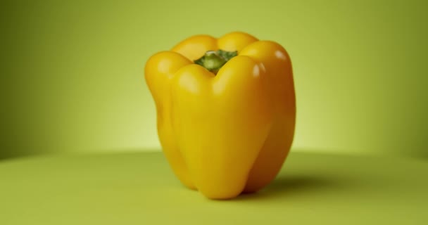 Вращение свежего желтого перца на зеленом фоне — стоковое видео