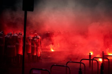 Sokak protestoları sırasında polis kordonu ve kırmızı fişekler