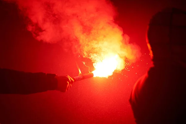 Şehirdeki bir sokak gösterisinde yanan kırmızı işaret fişeği — Stok fotoğraf