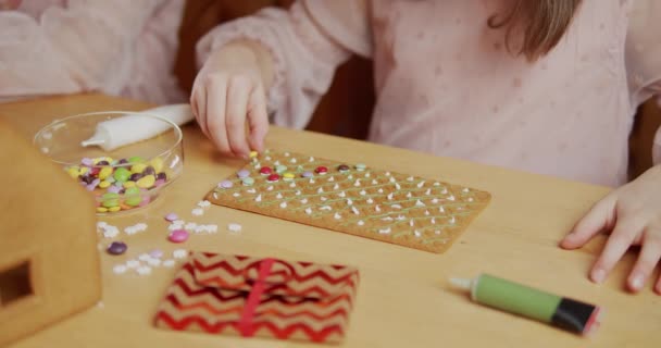 Roztomilé dívka stavět a zdobit perník vánoční dům — Stock video