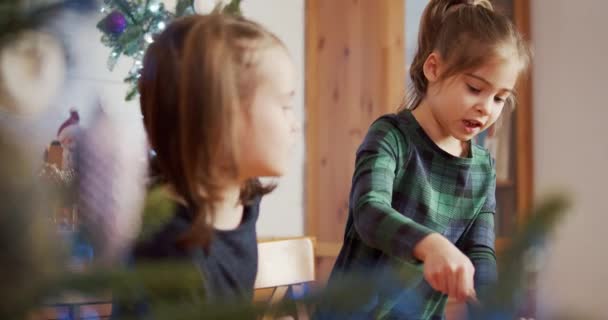 2人のかわいい姉妹がクリスマスジンジャーブレッドクッキーを作って飾る — ストック動画