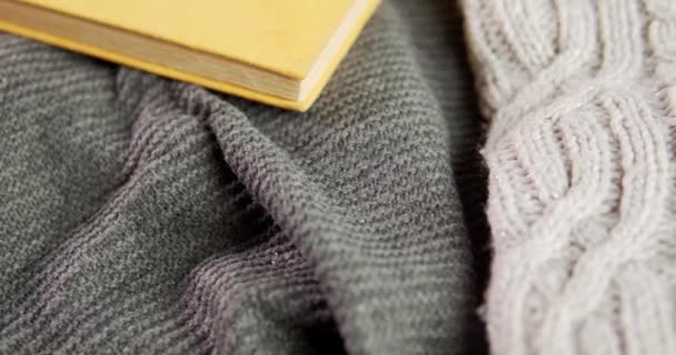 Details of a gray sweater and a small book — Stock Video