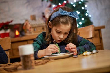 Tatlı kız zencefilli ekmek yapıp süslüyor.