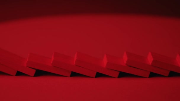 Rode dominostenen vallen in kettingreactie. Domino-effect. — Stockvideo