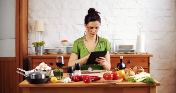 Schöne Frau checkt Rezept für Frühlingsessen auf dem Tablet — Stockvideo