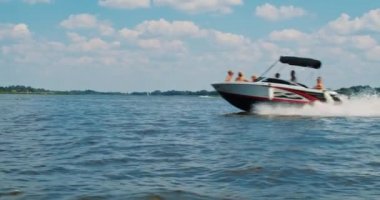 Nehirdeki motorlu tekne ve kıyı manzarası yavaş çekimde.