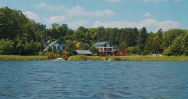 Nehirdeki motorlu tekne ve kıyı manzarası yavaş çekimde.