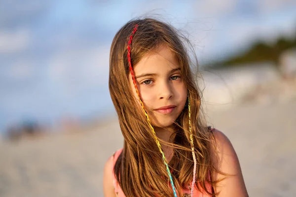 Potret seorang gadis kecil yang bahagia di pantai saat matahari terbenam Stok Gambar Bebas Royalti