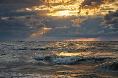 Fırtınadan sonra denizin üstünde destansı karanlık günbatımı gökyüzü. 