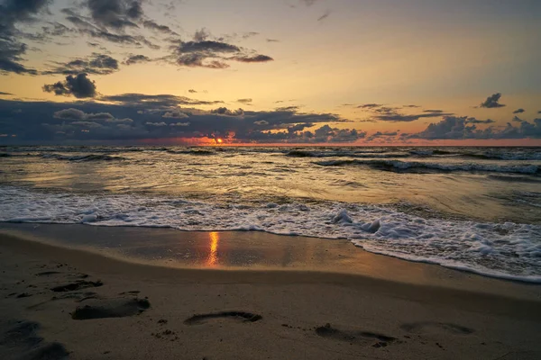 Epic matahari terbenam langit gelap di atas pantai laut setelah badai. Stok Foto