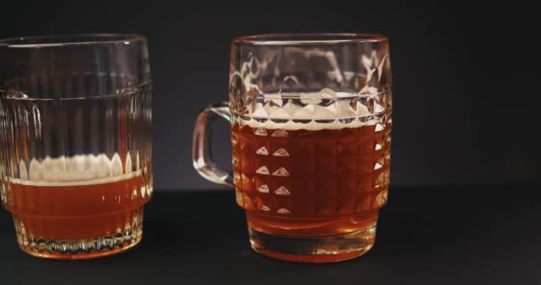 Vor dunklem Hintergrund Bier ins Glas gießen. Zeitlupe — Stockvideo