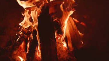 Canlı alevler kütüklerin etrafında dans ediyor, toplanma ve hikaye anlatma için mükemmel sıcak bir atmosfer yaratıyor.