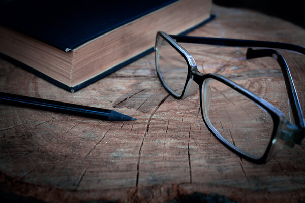 Book and glasses in the wooden table