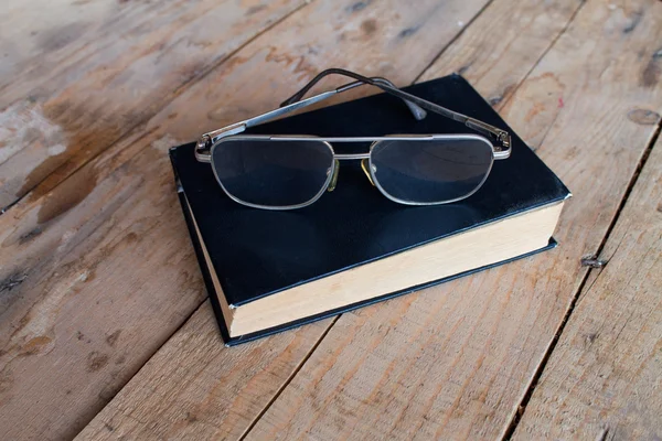 Libro y vasos en la mesa de madera — Foto de Stock