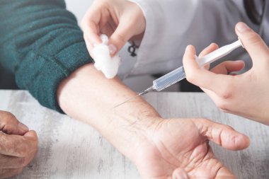  Doktor yaşlı kadına iğne yapıyor..