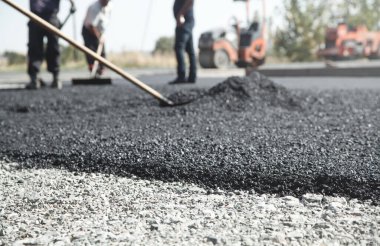 Asfalt düzenleyen işçiler. Yol yapımı. Sanayi