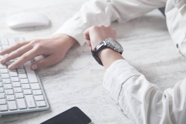 Kol saati elinde. Klavye kullanan insanlar
