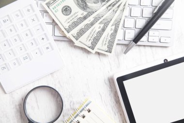 Bilgisayar klavyesi, tableti ve hesap makinesi olan 100 dolarlık banknotlar..