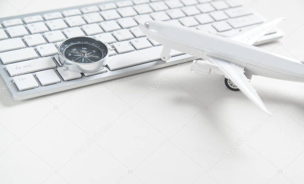 Airplane with computer keyboard and compass. Booking Online