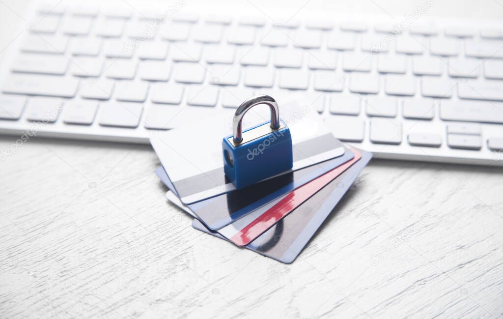 Padlock with credit cards on the computer keyboard.