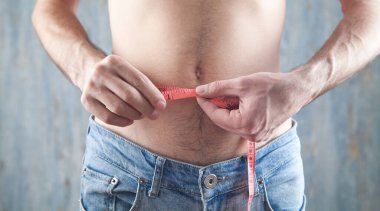 Ölçü bandı olan bir adam. Kilo kaybı