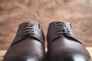 Ahşap arka planda kahverengi ayakkabılar..