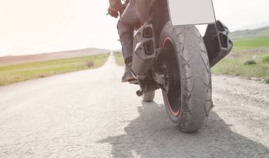 Motosiklet sürücüsü asfalt yolda tek başına gidiyor..